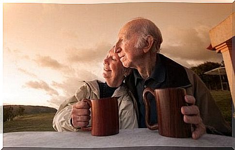 Elderly couple with mugs at dawn