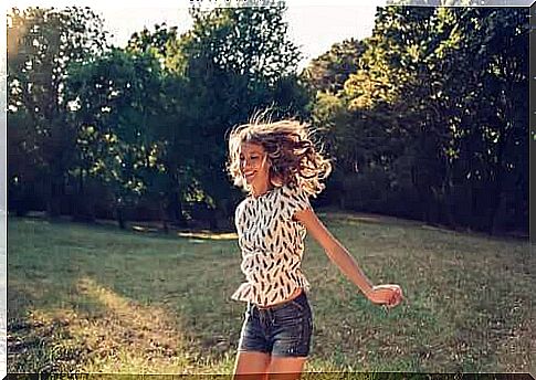 Happy woman jumping on a meadow.