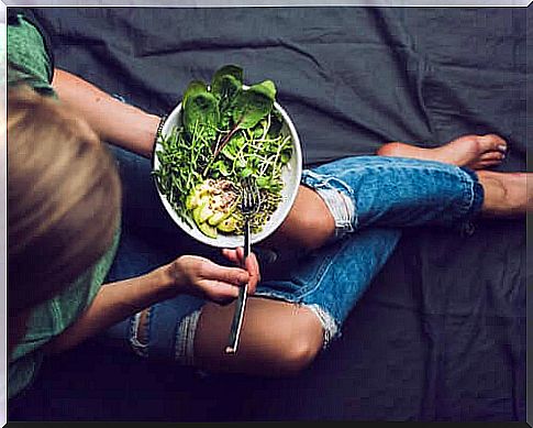 Young woman eating some vegetables