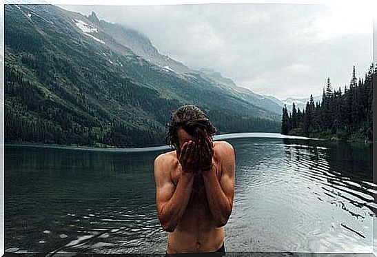 man bathes in mountain lake