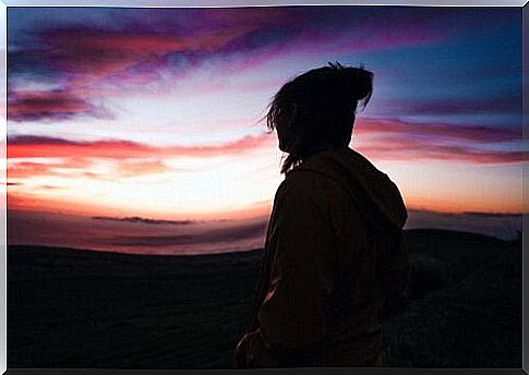 Woman watches sunset as she searches for her intrinsic motivation