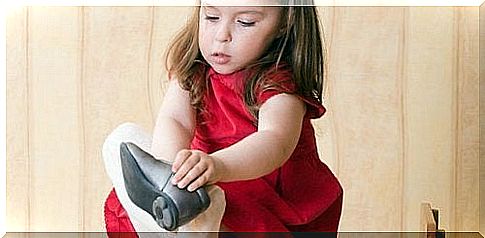 A little girl putting on shoes