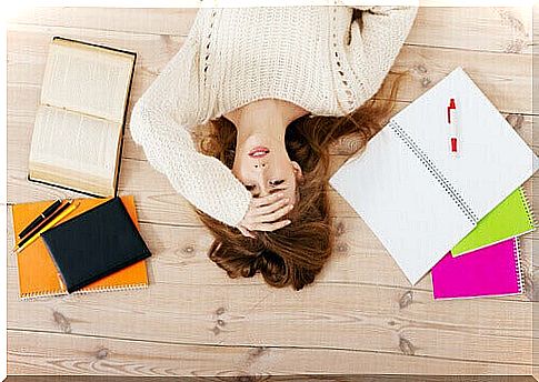 Stressed woman lying on the ground, as a representation of the 5 types of procrazrination