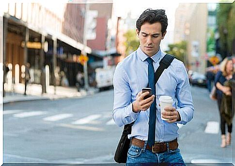 Smartphone zombie, man walking staring at cellphone