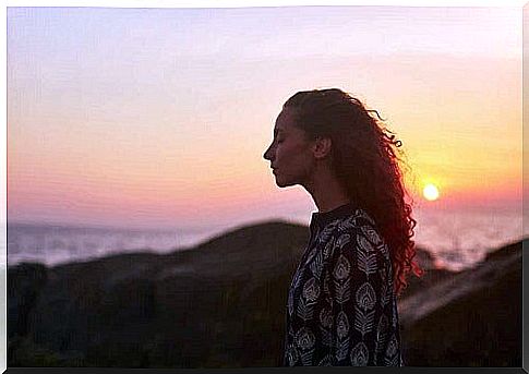 Woman reflecting during sunset.